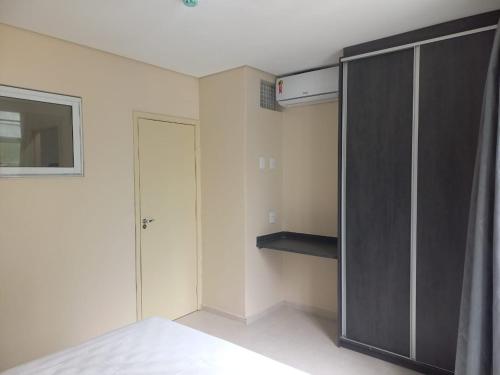 a bedroom with a bed and a black closet at Flat - Apartium Palacete Victória in Sao Paulo