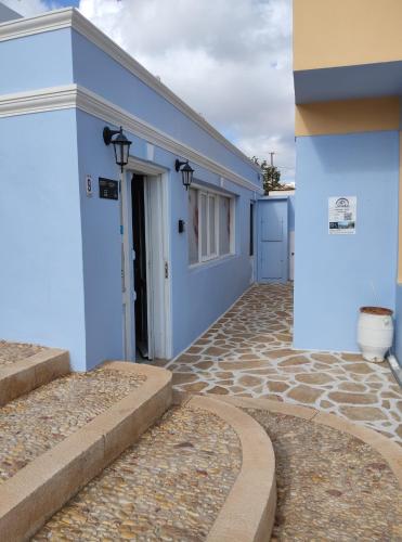 a blue building with stairs leading to a door at Anemi Leros Apartments 3 in Panteli