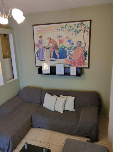 a living room with a couch and a painting on the wall at Anemi Leros Apartments 3 in Panteli