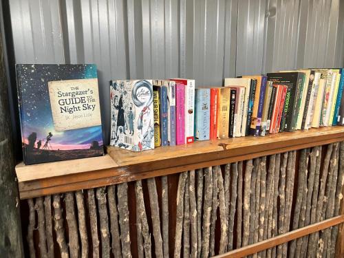 una estantería de madera con libros. en Kambu Mara Camp en Sekenani