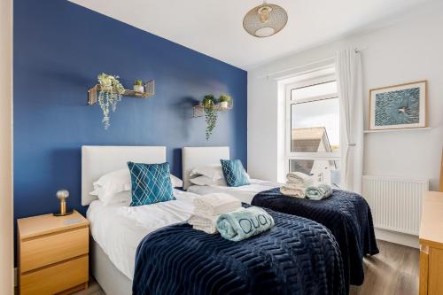 2 camas en una habitación con paredes azules en Southern Comfort, en Poole