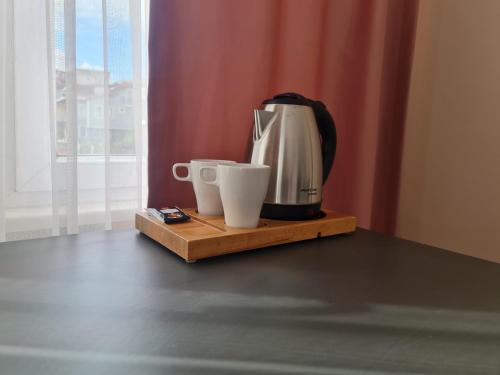 a coffee maker and two cups on a wooden tray at Budget Hotel Tourist Inn in Arnavutköy