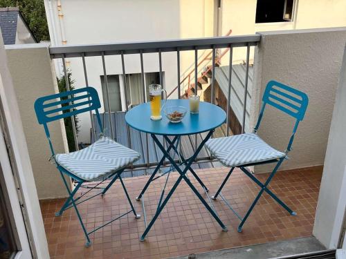 une table bleue et deux chaises sur un balcon dans l'établissement Appartement au cœur du Pouliguen, proche mer, 2 pièces, 4 couchages, parking privé, tout à pied - FR-1-245-32, au Pouliguen