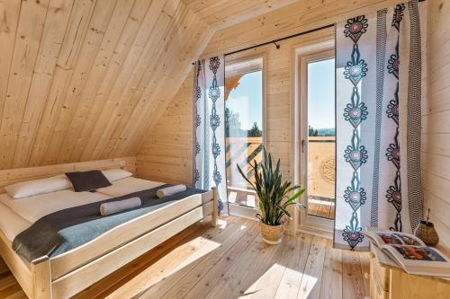 1 dormitorio con 1 cama en una habitación de madera con ventana en Pienińska Przystań, en Czorsztyn