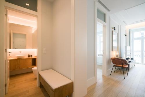 un bagno con una panca e un tavolo in una stanza di Luxury condo in heart of Baixa-Chiado a Lisbona
