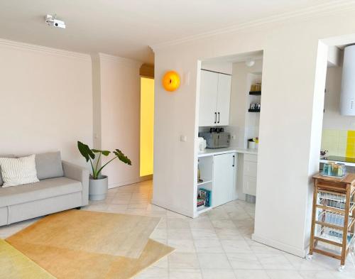 a living room with a couch and a kitchen at Groovy Caparica Gem with Large Sunny Terrace in Costa da Caparica