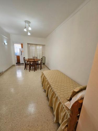 Habitación con cama, mesa y sillas. en Departamento en Plaza mitre! en Mar del Plata