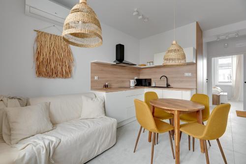 a living room with a couch and a table and chairs at Przypływ by Grand Apartments in Gdynia