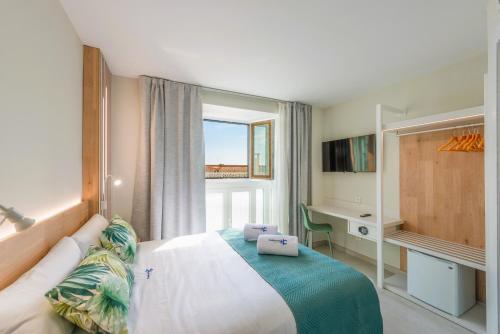 a bedroom with a bed and a desk and a window at HC Calahonda Beach Nerja in Nerja