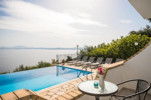 a patio with a table and chairs next to a swimming pool at Four-Bedroom Villa Eleni by Konnect, with Private Pool & Stunning Seaview in Barbati