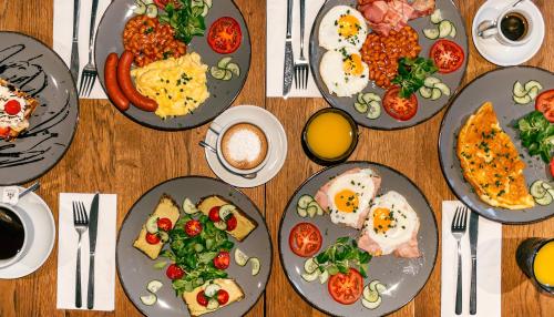 a table with plates of breakfast food on it at Hotel Ikona in Prague