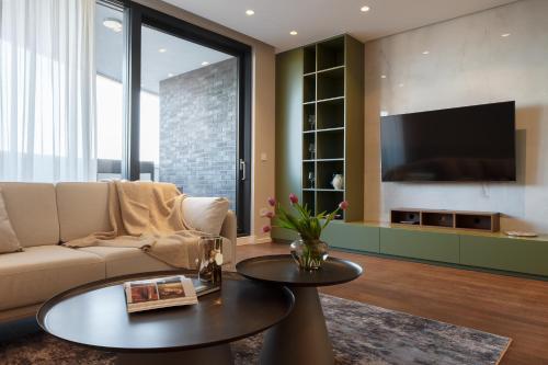 sala de estar con sofá y TV en Sky-High Luxury - City's Best View en Novi Sad
