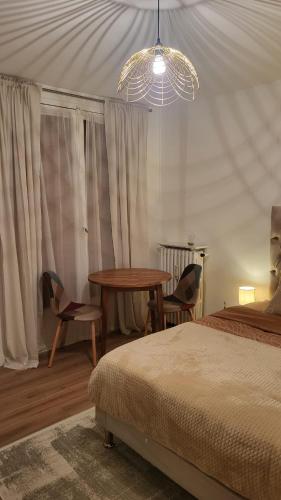een slaapkamer met een tafel en stoelen en een bed bij Château 5 min avec balcon et un Stationnement gratuit in Versailles