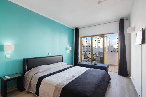 - une chambre avec un lit et une grande fenêtre dans l'établissement Apartamento da Rocha I, à Portimão