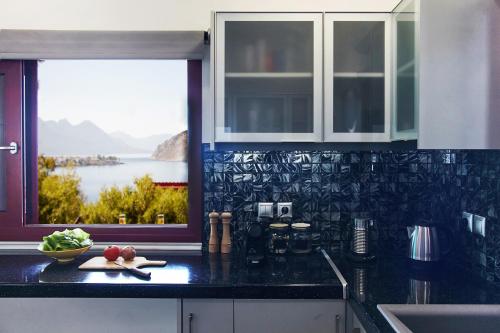 a kitchen counter with a window with a view of the water at The Bordeaux Door in Aegina Town