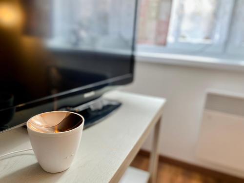 a cup of coffee sitting on a table in front of a television at Ubytovanie Stratený budzogáň in Kľače