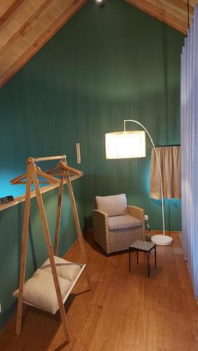 a living room with a green wall and a swing at Chez Rosé in Sainte-Cécile