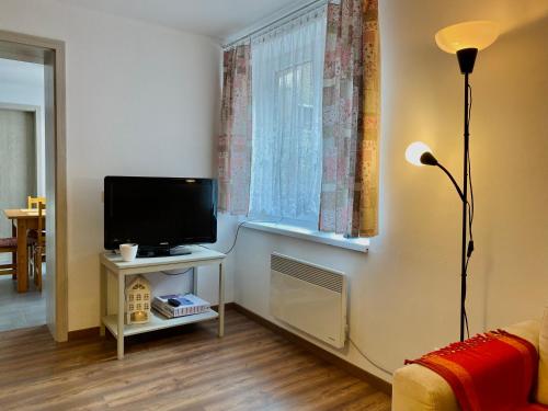 a living room with a television and a window at Ubytovanie Stratený budzogáň in Kľače