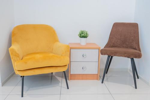 two chairs next to a side table with a plant at Ipoh Tambun Sunway Onsen Suite 3R2B Maya in Tambun