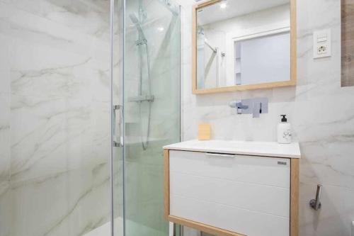 een badkamer met douche, wastafel en spiegel bij Apartamento Arresi Deluxe in Bermeo