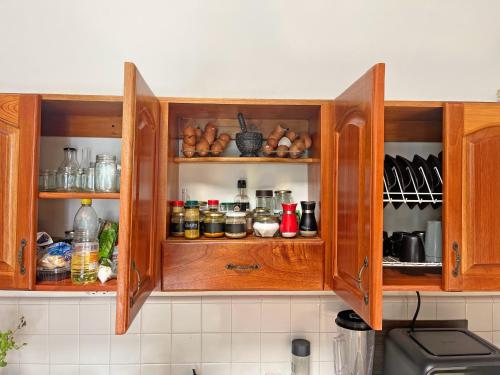 a kitchen with wooden cabinets filled with food at Hostal El fin del afán in Jericó