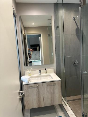 a bathroom with a sink and a shower at Menylyn Maine Residences Trilogy 913 in Pretoria