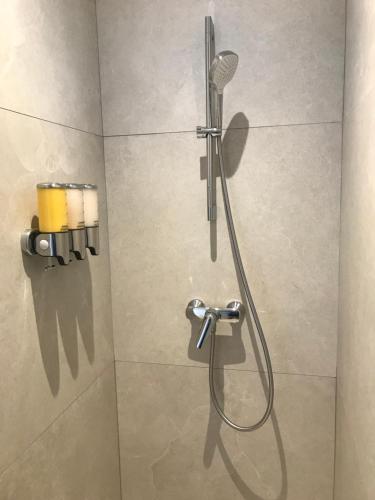 een douche met een douchekop in de badkamer bij Bord de mer aux Pins Penchés in Carqueiranne