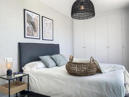 een slaapkamer met een bed met een mand erop bij Via Celere 2335 Golf & Sea view in Casares