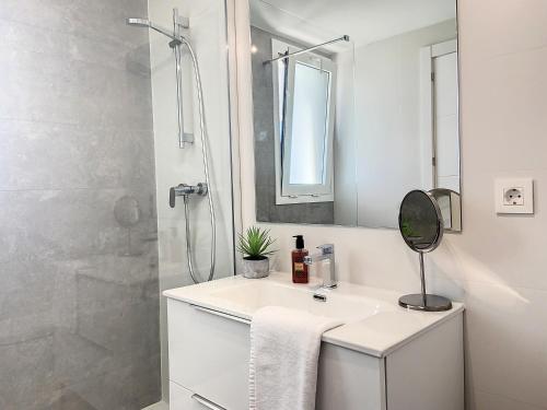 een witte badkamer met een wastafel en een douche bij Via Celere 2335 Golf & Sea view in Casares