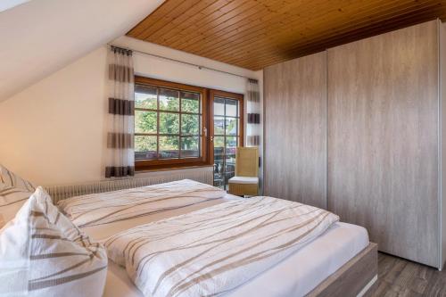 um quarto com uma cama grande e uma janela em Haus Morgensonne em Höchenschwand