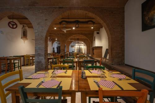 uma sala de jantar com mesas e cadeiras de madeira em Podere Valserena em Monteroni dʼArbia