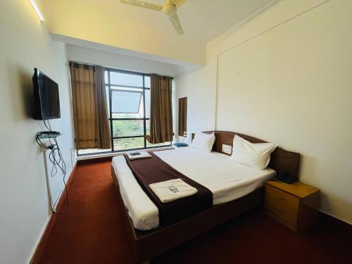 een hotelkamer met een bed en een raam bij ZEKE HOTELS in Bangalore