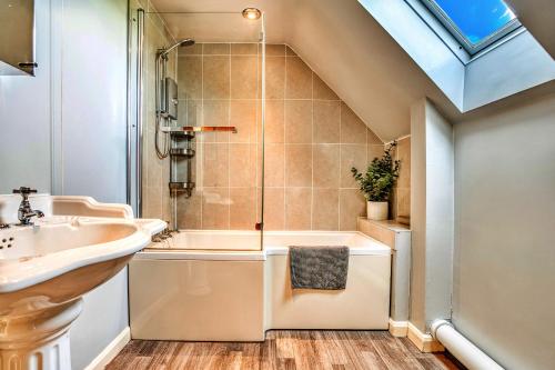 a bathroom with a sink and a bath tub at Finest Retreats - Gag Barn in Ashbourne