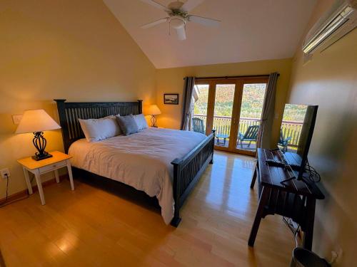 um quarto com uma cama e uma varanda em CR16 Ski-in/Out luxury home mountain views Bretton Woods em Bretton Woods