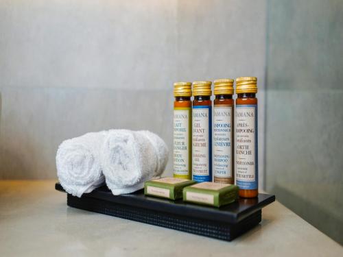 a shelf with four bottles of essential oils and a towel at Petit Palace Suites Hotel in Agadir