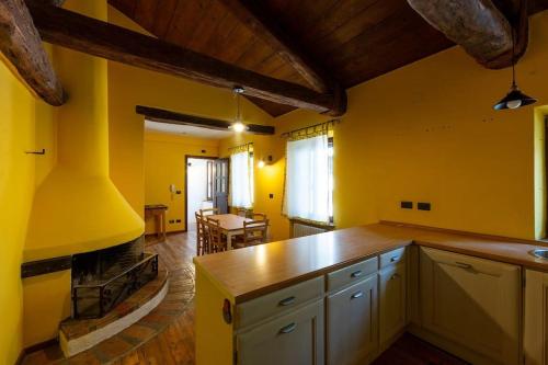 una cucina con pareti gialle e piano di lavoro di Relais Castel d'Emilio – Casa ARANCIO a Cassero