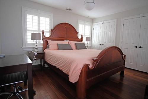 a bedroom with a large wooden bed with pink sheets at Carriage House B at Hamilton in Savannah