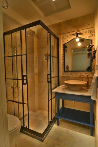 a bathroom with a sink and a shower with a mirror at SUR PALACE OTEL in Diyarbakır