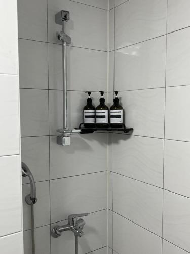 two bottles of medicine sitting on a shelf in a shower at The Shim Anam 3rooms late check in-out in Seoul