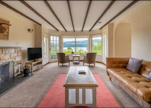 a living room with a couch and a fireplace at Loch Ness Cottages in Brackla