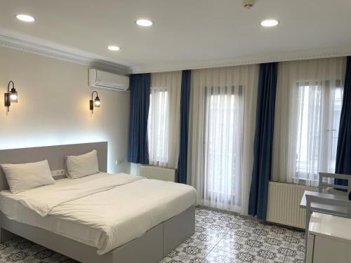 1 dormitorio con 1 cama grande y cortinas azules en Royal Pera Taksim, en Estambul