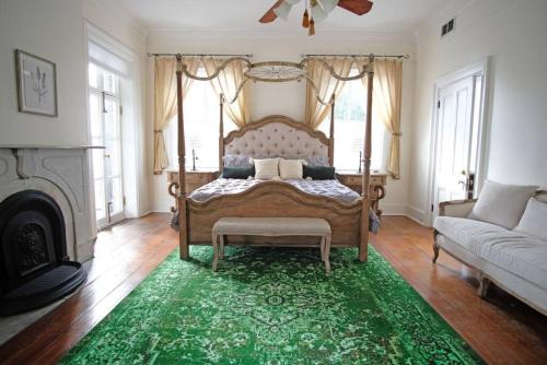 a bedroom with a bed with a green rug at 8BR Historic Hamilton House in Savannah