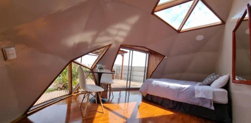 a attic bedroom with a bed and a window at Domos kupellon in Santiago