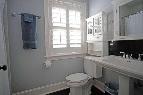 uma casa de banho branca com um WC e um lavatório em Carriage House A at Hamilton em Savannah