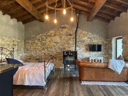 a bedroom with a bed and a couch and a tv at The Sanctuary in Pontremoli