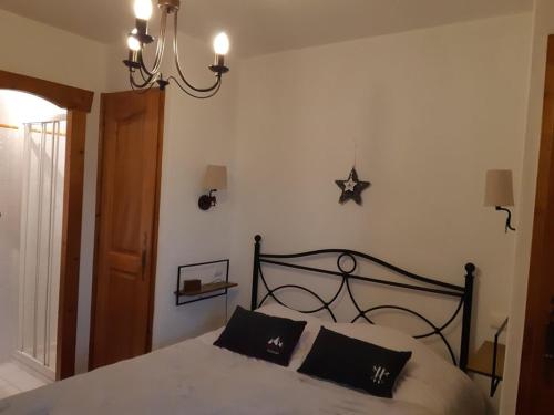 - une chambre avec un lit et deux oreillers noirs dans l'établissement Appartement avec piscine chauffée, terrasse, parkings et 2 chambres - FR-1-733-126, à Crest-Voland