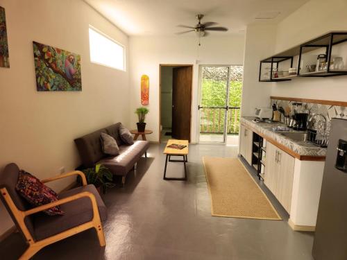 ein Wohnzimmer mit einem Sofa und einer Küche in der Unterkunft El Hábita CASA MAR in Playa Santa Teresa