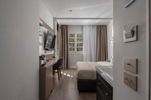 a hotel room with a bed and a desk and a sink at No 39 Svolou Suites in Thessaloniki