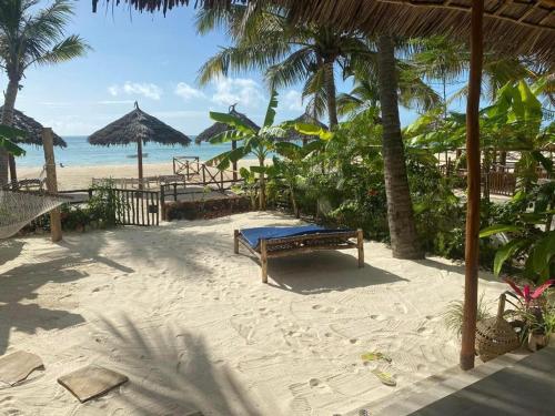 a bench on a beach with a view of the ocean at Namayani apartment in Pwani Mchangani