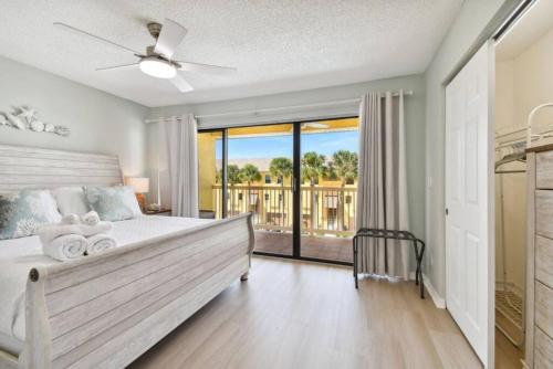 a bedroom with a large bed and a balcony at Serene Sunsets at Indian Cove in Clearwater Beach